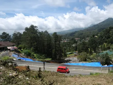 Kendaraan melintasi di sekitar area yang longsor di kawasan Ciloto, Cianjur, Jawa Barat, Sabtu (31/3). Longsor yang terjadi pada Rabu (28/3) lalu diduga adanya pergerakan tanah sehingga menyebabkan longsor. (Liputan6.com/Helmi Fithriansyah)