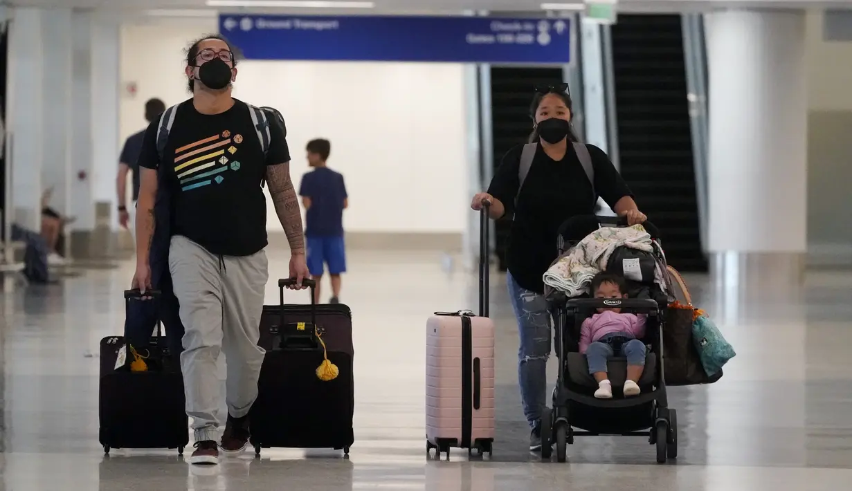 <p>Pelancong membawa barang bawaan mereka di area pengambilan bagasi di Bandara Internasional Los Angeles, Senin (25/4/2022). Seminggu sebelumnya, seorang hakim federal di Florida menolak persyaratan untuk memakai masker di bandara dan selama penerbangan. Aturan itu, yang dirancang untuk membatasi penyebaran COVID-19, akan berakhir pada 3 Mei. (AP Photo/Marcio Jose Sanchez)</p>