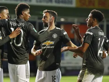 Para pemain Manchester United merayakan gol yang dicetak oleh Marcus Rashford ke gawang Luton Town pada Piala Liga Inggris di Stadion Kenilworth Road, Rabu (23/9/2020). Setan Merah menang dengan skor 3-0. (Nick Potts/Pool via AP)
