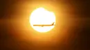 Sebuah pesawat terbang melewati gerhana matahari parsial yang terjadi di Singapura, Rabu (9/3/2016). Gerhana matahari parsial di Singapura terakhir kali terjadi pada 10 Mei 2013 lalu. (REUTERS / Edgar Su)