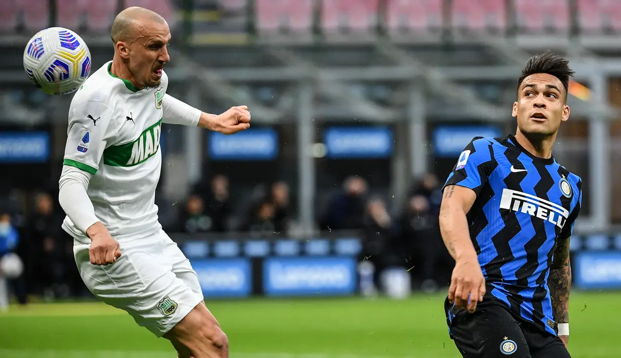 Bek Sassuolo, Vlad Chiriches (kiri) dan penyerang Inter Milan, Lautaro Martinez mengejar bola pada laga tunda Liga Italia di Stadio Giuseppe Meazza, Kamis (8/4/2021) dini hari WIB. Bermain di kandang, Inter Milan mengalahkan Sassuolo dengan skor 2-1. (Isabella BONOTTO / AFP)