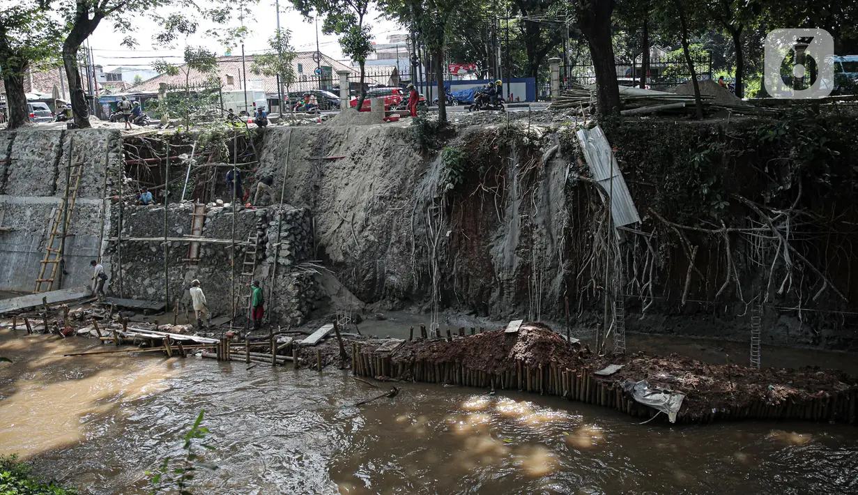 Suasana pengerjaan turap di bantaran Kali Kramat Jati, Jakarta, Jumat (20/1/2023). Pembangunan turap bertujuan untuk mencegah longsor yang dapat membahayakan warga sekitar. (Liputan6.com/Faizal Fanani)