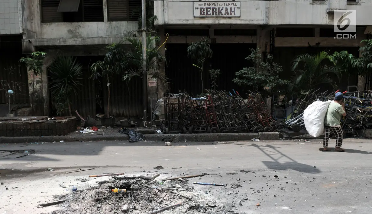 Seorang pemulung melintasi sisa kericuhan di sekitar Pasar Tanah Abang, Jakarta, Rabu (22/5/2019). Tak ada aktivitas perdagangan pagi ini di Pasar Tanah Abang , menyusul aksi 22 Mei 2019. (merdeka.com/Iqbal S Nugroho)