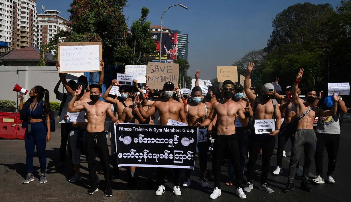 Sejumlah binaragawan dengan membawa poster dan spanduk ambil bagian dalam protes menentang kudeta militer di Yangon, Myanmar, Kamis (11/2/2021). Memasuki hari keenam, demonstrasi menentang kudeta Myanmar dari berbagai elemen masyarakat terus berlangsung. (Sai Aung Main / AFP)