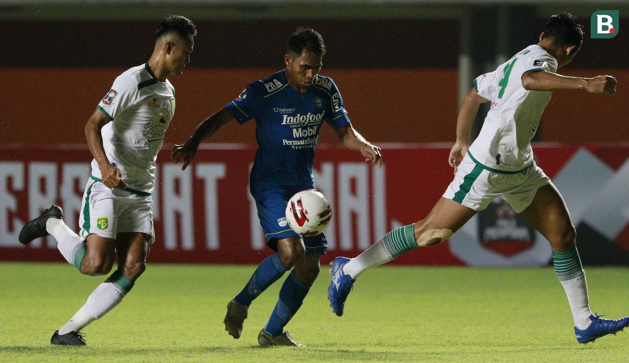 Striker Persib Bandung, Frets Butuan (tengah) berusaha melewati dua pemain Persebaya Surabaya dalam laga perempatfinal Piala Menpora 2021 di Stadion Maguwoharjo, Sleman, Minggu (11/4/2021). Persib menang 3-2 atas Persebaya. (Bola.com/M Iqbal Ichsan)