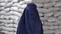 Seorang perempuan Afghanistan menunggu untuk menerima jatah makanan yang didistribusikan oleh kelompok bantuan kemanusiaan Korea Selatan, di Kabul, Selasa (10/5/2022). Taliban pada Sabtu pekan lalu memerintahkan semua perempuan Afghanistan menutupi seluruh tubuhnya atau mengenakan burqa tradisional di depan umum. (AP Photo/Ebrahim Noroozi)