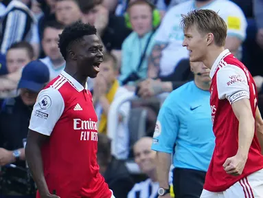 Gelandang Arsenal, Martin Odegaard (kanan) berselebrasi dengan rekannya Bukayo Saka setelah mencetak gol ke gawang Newcastle United pada pertandingan lanjutan Liga Inggris di di stadion St James 'Park di Newcastle, Minggu, 7 Mei 2023. (AP Photo/Jon Super)