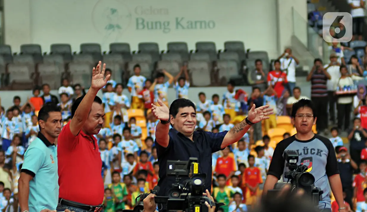 Legenda sepak bola Argentina Diego Maradona (tengah) menyapa penggemarnya saat datang ke Stadion Gelora Bung Karno (GBK), Senayan, Jakarta, Sabtu (29/6/2013). Diego Maradona dikabarkan meninggal dunia karena serangan jantung. (Liputan6.com/Helmi Fithriansyah)