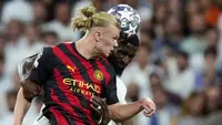 Pemain Manchester City, Erling Haaland (kiri) berebut bola dengan pemain Real Madrid, Antonio Rudiger pada laga leg pertama semifinal Liga Champions 2022/2023 di Santiago Bernabeu, Madrid, Rabu (10/05/2023) WIB. Laga berakhir dengan skor 1-1. (AP Photo/Manu Fernandez)