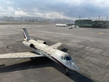 Sebuah pesawat diselimuti abu vulkanik di bandara internasional La Aurora yang telah ditutup akibat letusan di gunung berapi Pacaya di Guatemala City (23/3/2021). (AP Photo / Moises Castillo )