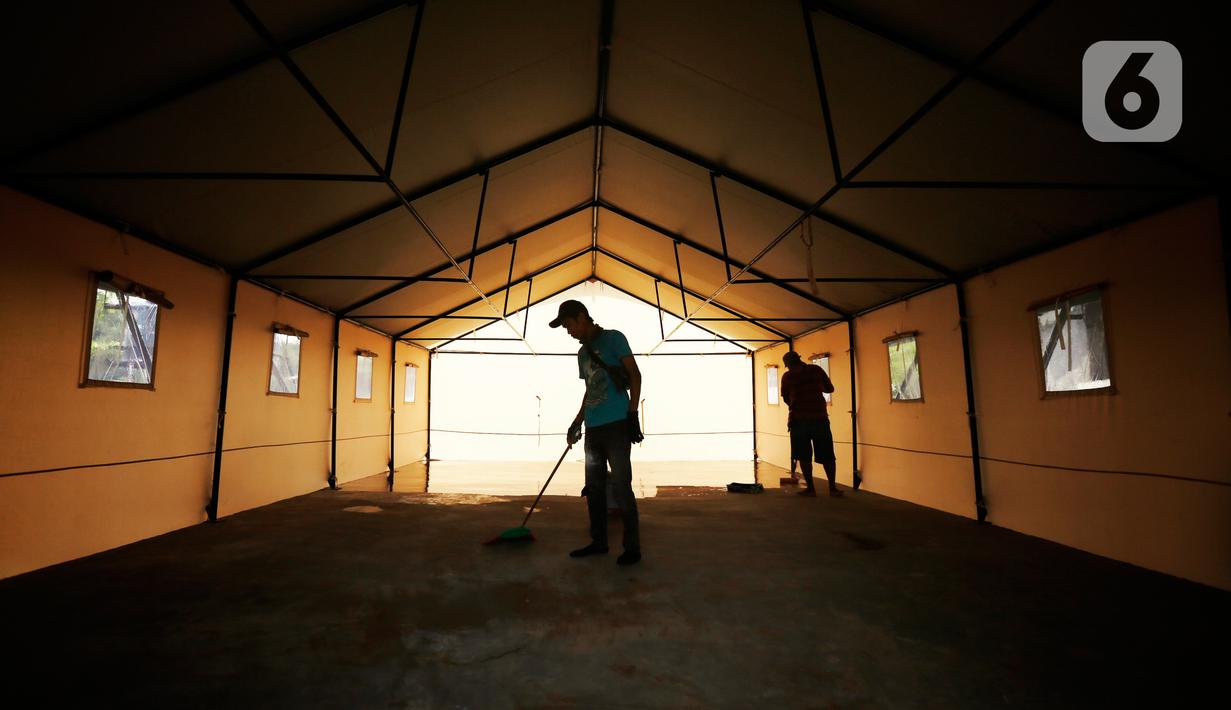 Pekerja membersihkan tenda darurat untuk ruang isolasi di Rumah Lawan COVID (RLC) Serpong, Tangerang Selatan, Kamis (11/2/2021). Pemkot Tangsel membangun tenda darurat berkonsep Tenda Glamour Camping (glamping) untuk menampung pasien Covid-19 di pusat karantina itu. (Liputan6.com/Angga Yuniar)