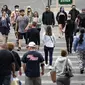 Pejalan kaki dengan masker dan tanpa masker berjalan di sepanjang Las Vegas Strip, di Las Vegas Selasa (27/4/2021). Warga Amerika Serikat (AS) yang telah menerima vaksin COVID-19 tidak lagi diwajibkan mengenakan masker saat berada di luar ruangan jika tidak ada kerumuman. (AP Photo/John Locher)