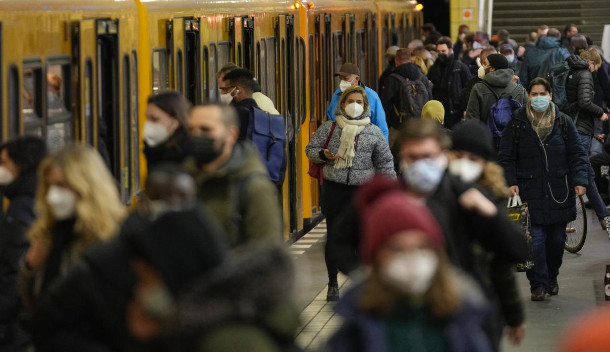 Warga memakai masker untuk melindungi diri dari COVID-19 di stasiun transportasi umum Friedrichstrasse, Berlin, Jerman, Selasa (30/11/2021). Otoritas Jerman mewajibkan penggunaan masker di transportasi umum dan penumpang perlu divaksinasi, pulih atau negatif COVID-19. (AP Photo/Markus Schreiber)