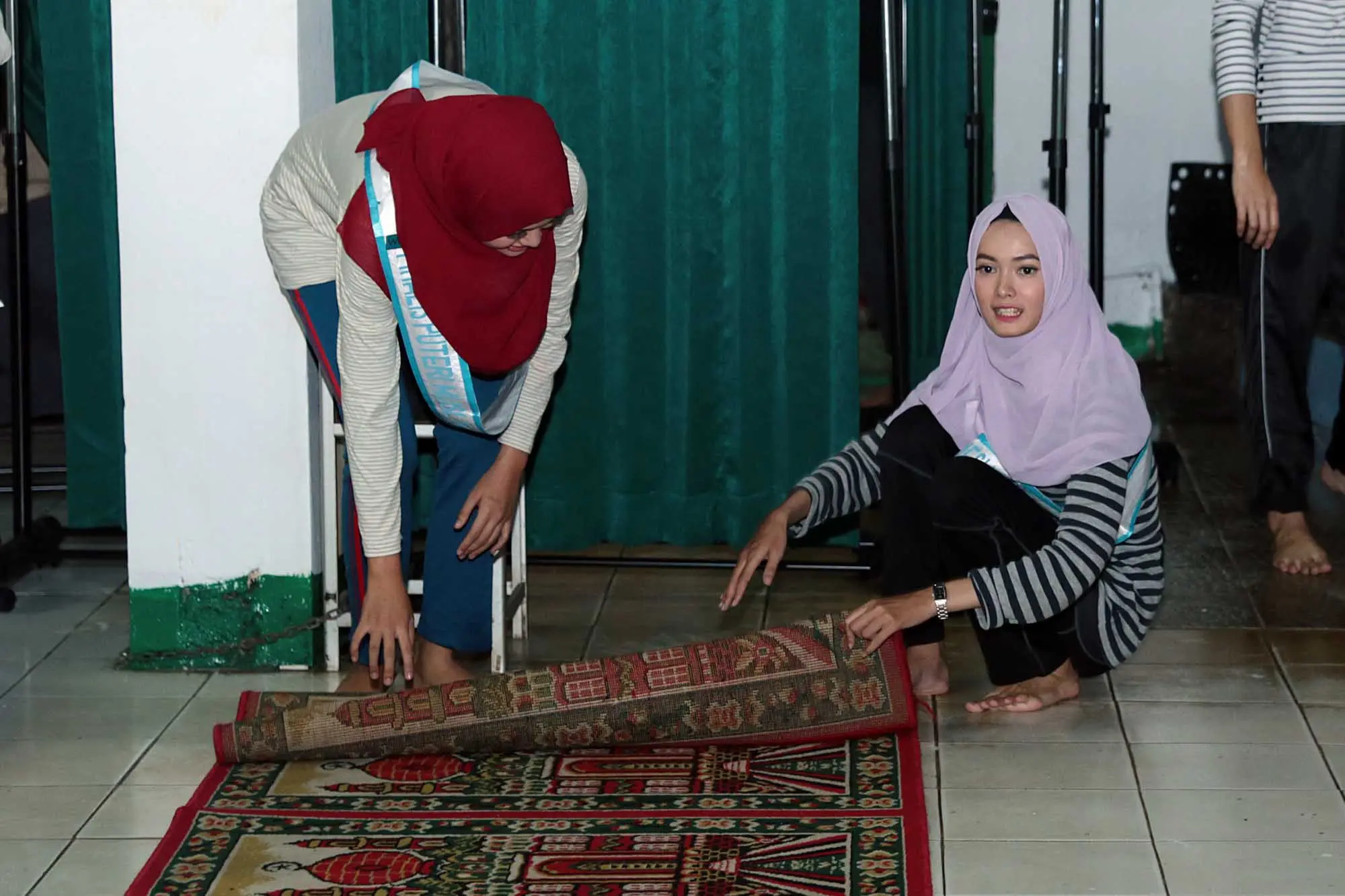 Finalis Puteri Muslimah Indonesia sedang membersihkan sebuah musala sebagai bagian dari kegiatan. (Deki Prayoga/Bintang.com)