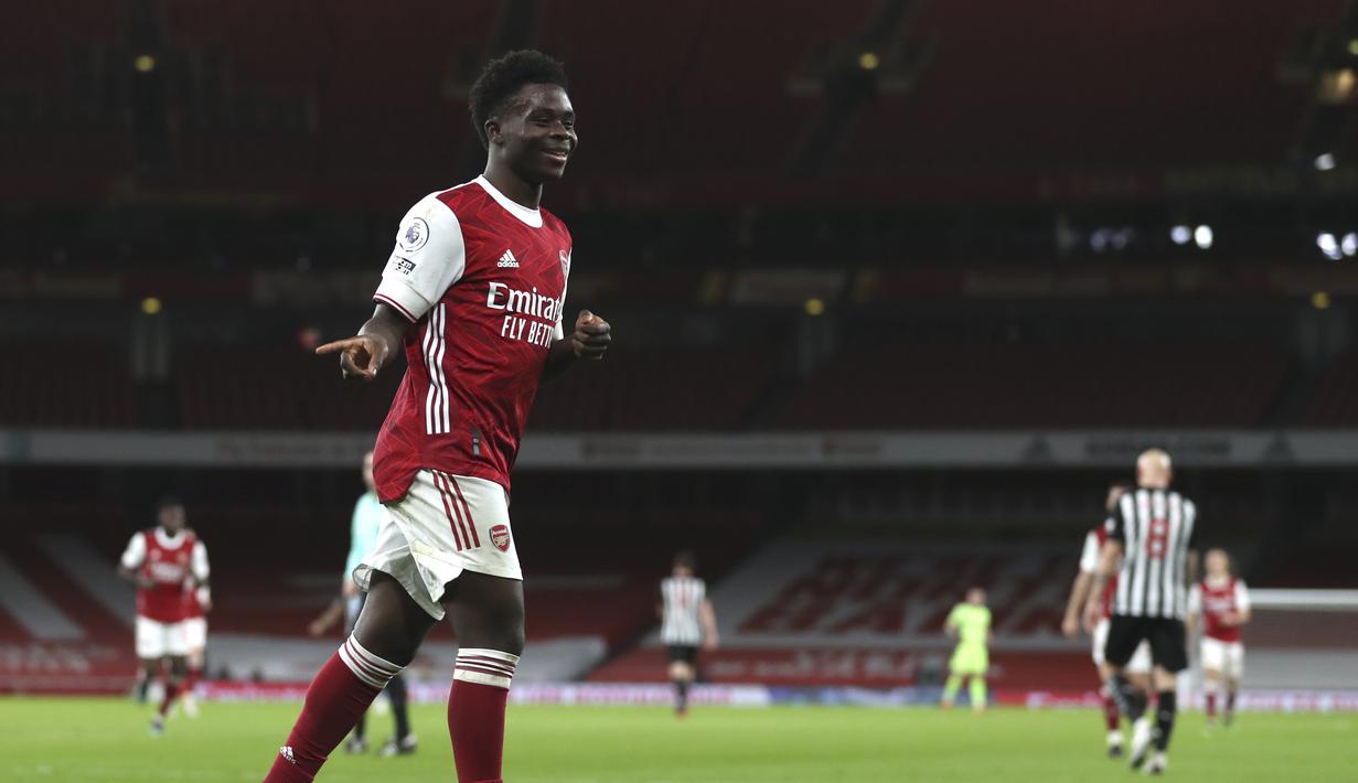 Gelandang Arsenal, Bukayo Saka berselebrasi usai mencetak gol ke gawang Newcastle United pada pertandingan Liga Inggris di Stadion Emirates di London, Selasa (19/1/2021). (Catherine Ivill/Pool via AP)