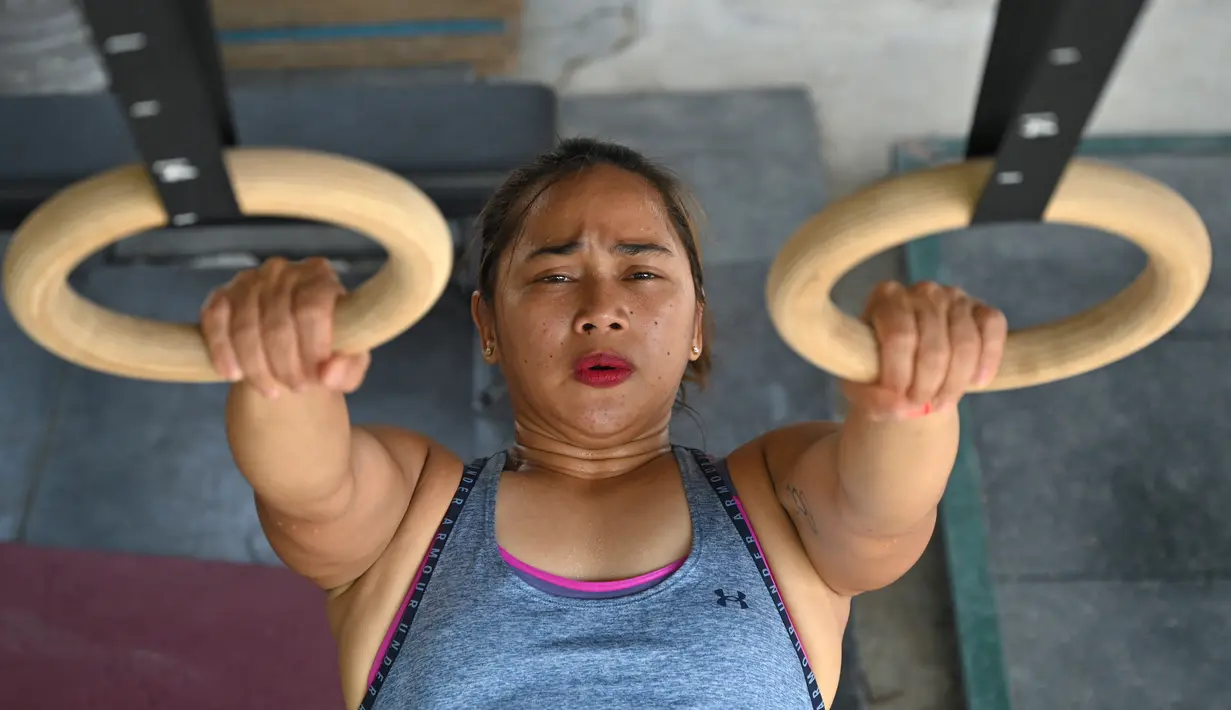 Gambar pada 21 Mei 2021 menunjukkan atlet angkat besi Olimpiade dari Filipina, Hidilyn Diaz mengikuti sesi latihan di Jasin di kota Malaka, Malaysia. Diaz (30) yang memenangkan perak di Rio 2016 lalu telah tertahan di Malaysia sejak Februari 2020 karena pandemi virus corona (Mohd RASFAN/AFP)