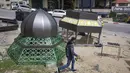 Buruh Palestina mengerjakan monumen bergaya Islam yang terdiri dari lentera dan bulan sabit, dua ikon simbolik bulan suci Ramadhan, di Kota Ramallah, Tepi Barat, 29 Maret 2022. Alun-alun utama di pusat Kota Ramallah akan diterangi untuk merayakan Ramadhan. (AP Photo/Nasser Nasser)