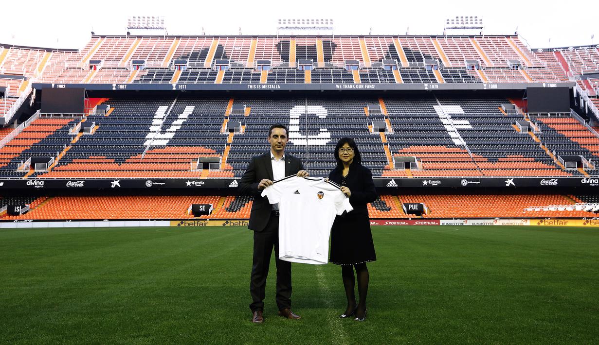 Mantan Pemain Manchester United, Gary Neville (kiri) berfoto bersama salah satu pemilik Klub Valencia, Lay Hoon Chan pada acara perkenalan sebagai pelatih di Stadion Mestalla, Kamis (3/12/2015).  (AFP Photo/Jose Jordan)