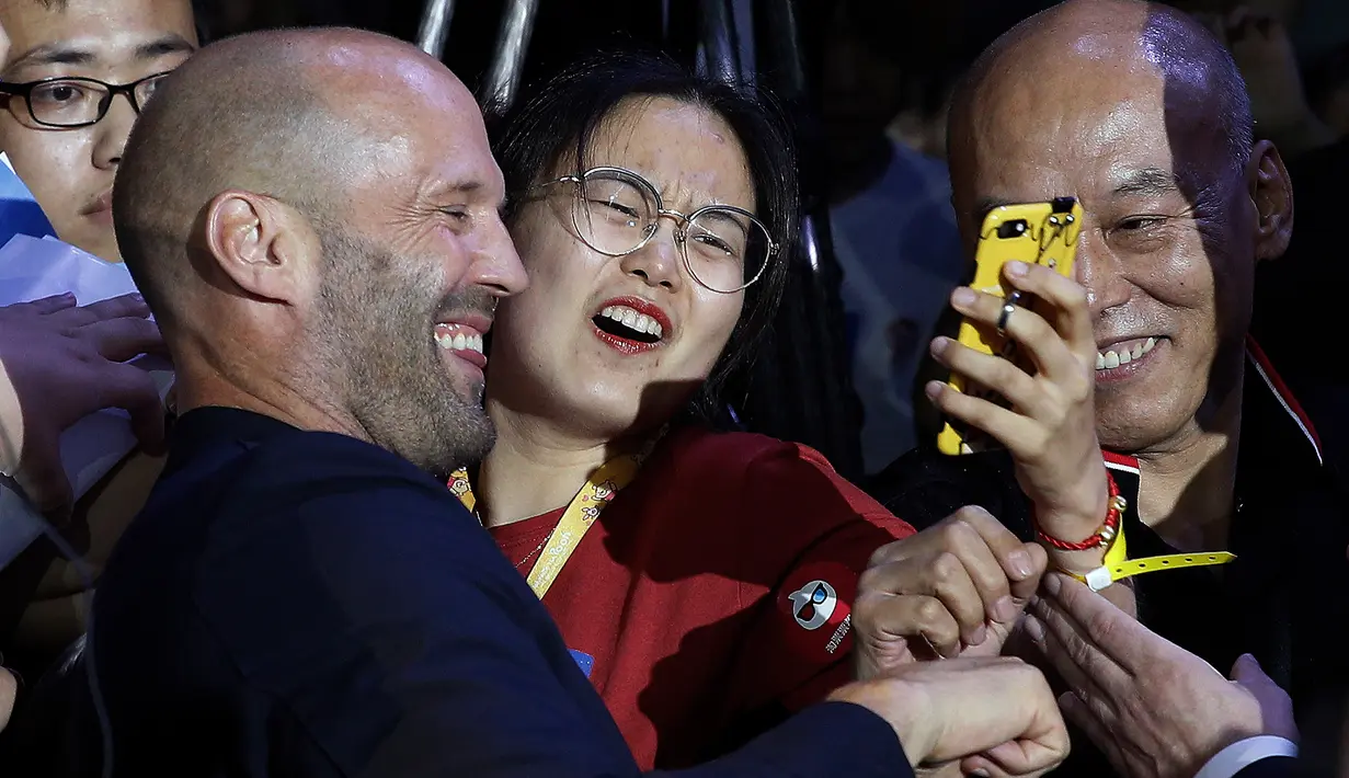 Aktor Jason Statham berswafoto bersama penggemar selama acara red carpet dalam premiere film 'Fast & Furious: Hobbs & Shaw' di Beijing, China, Senin (5/8/2019). Hobbs and Shaw menempatkan dua aktor laga papan atas, Jason Statham dan Dwayne Johnson sebagai pemeran utama. (AP Photo/Andy Wong)