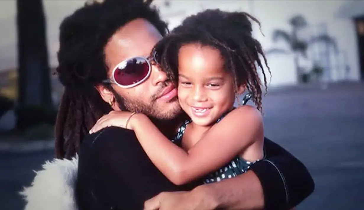 Tebak cewek ompong yang tengah dalam pelukan sang ayah ini siapa? Dia pun ikut berperan dalam film Divergent, lho. Ia adalah Zoe Kravitz! (RehabCenterNearMe)