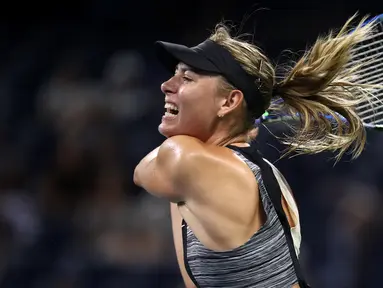 Petenis Rusia, Maria Sharapova mengembalikan bola Patty Schnyder dari Swiss pada pertandingan tunggal pertama putri AS Terbuka 2018 di New York, (28/8). Sharapova tampil sengit melawan petenis berusia 39 tahun tersebut. (AFP Photo/Julian Finney)