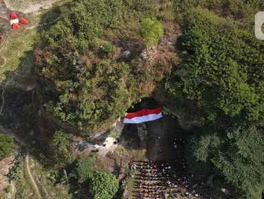 Foto udara upacara pengibaran bendera Merah Putih pada HUT ke-78 RI di lokasi bekas tambang batu kapur Tebing Arpam, Gua Sigugula Karst Klapanunggal, Kabupaten Bogor, Jawa Barat, Kamis (17/8/2023).  (merdeka.com/Imam Buhori)