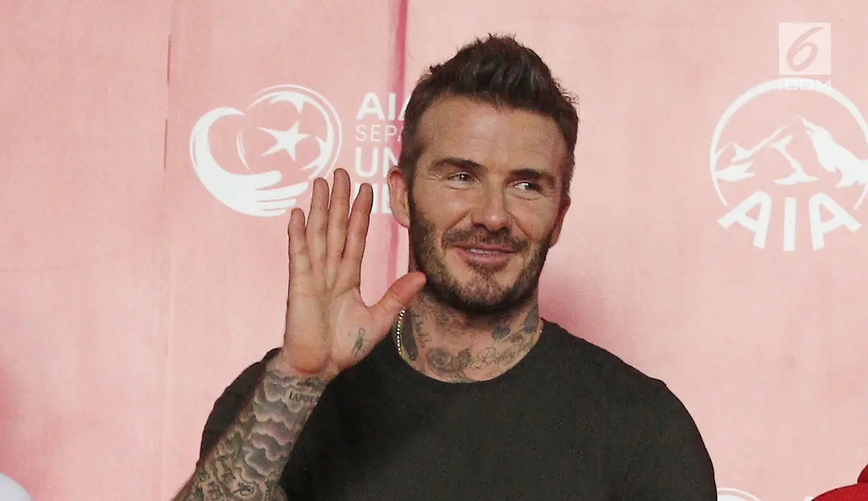 Mantan bintang sepak bola Inggris David Beckham melambaikan tangan kepada fans saat acara AIA Sepak Bola untuk Negeri di Jakarta, Minggu (25/3). Kegiatan David dan AIA membagikan 10 ribu bola untuk akademi sepak bola. (Liputan6.com/Herman Zakharia)