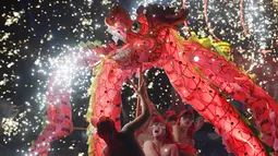 Penari melakukan tarian naga di sebuah taman pada hari keempat Tahun Baru Imlek di Beijing (8/2). China menandai kedatangan Tahun Babi dengan liburan Festival Musim Semi selama seminggu.  (AFP Photo/Greg Baker)
