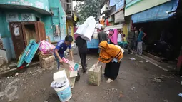 Warga mengangkut perabotan mereka ke mobil bak terbuka di kawasan Bukit Duri, Jakarta, Kamis (8/9). Jelang penertiban, warga di kawasan itu berinisiatif mengemas barang untuk pindah ke Rusun Rawa Bebek pascaterbitnya SP II (Liputan6.com/Immanuel Antonius)