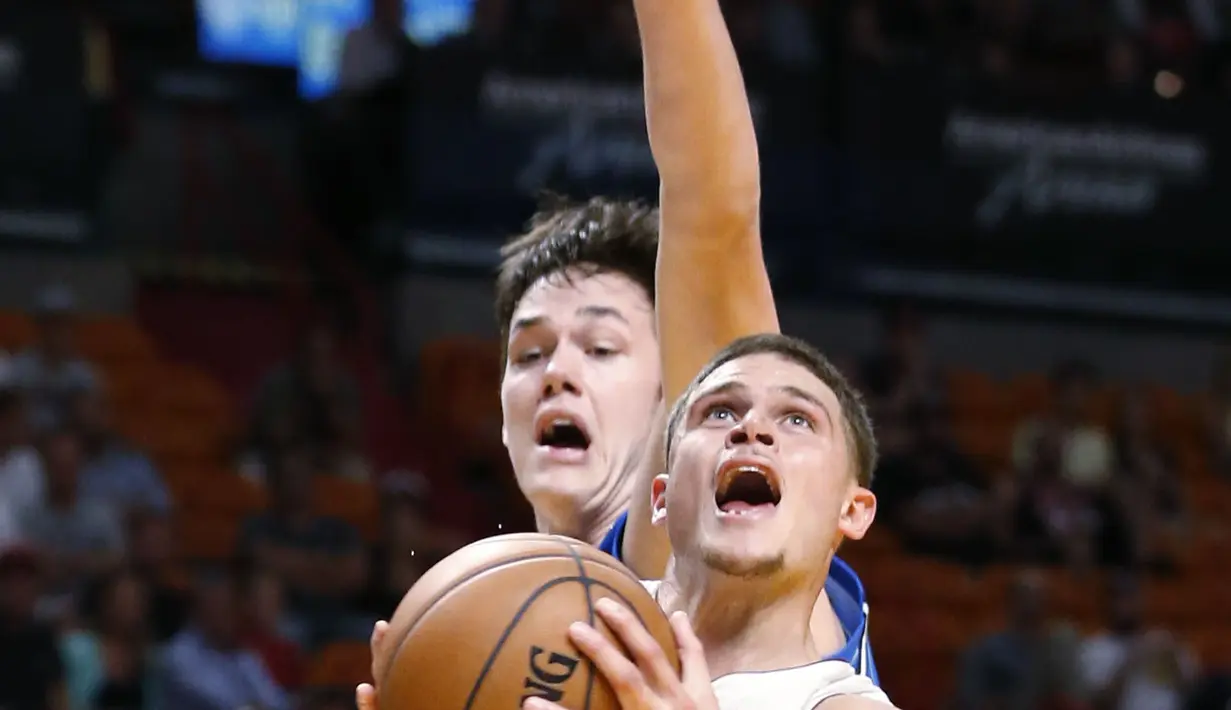 Pemain Miami Heat, Tyler Johnson #8 mencoba melakukan tembakan saat dihadang pemain Orlando Magic, Stephen Zimmerman Jr. pada laga NBA preseason basketball game, di Miami (19/10/2016) WIB. (AP/Wilfredo Lee)