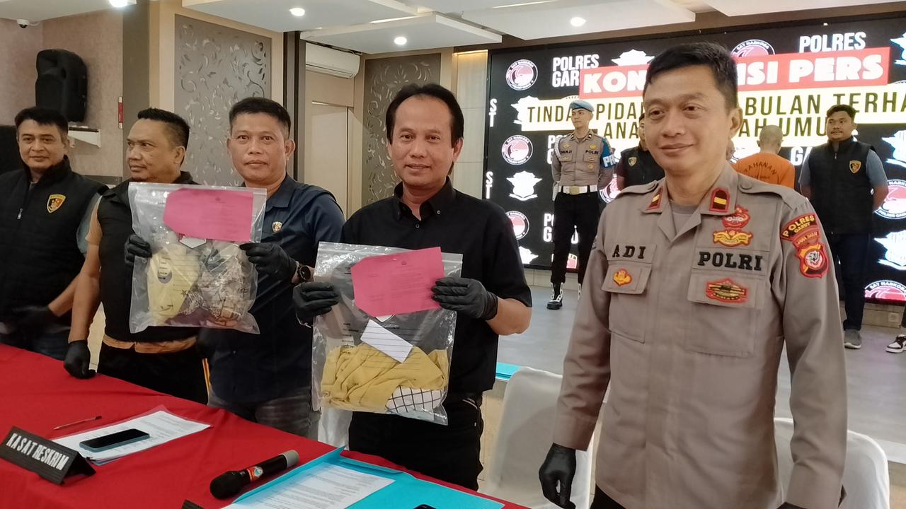 Kasat Reskrim Polres Garut AKP Joko Prihatin dan Ketua KPAID Tasikmalaya Ato Rinanto, menunjukan alat bukti, dalam rilis kasus di mapolres Garut, Jumat (11/4/2025). (Liputan6.com/Jayadi Supriadin)