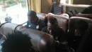 Pemain Sriwijaya FC relaks dengan gadget masing-masing saat perjalanan menuju Stadion Utama Gelora Bung Karno, Jakarta, Minggu (18/10/2015). (Bola.com/Nicklas Hanoatubun)