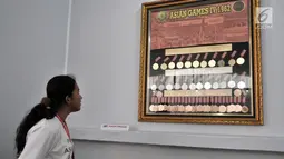 Pengunjung melihat koleksi medali yang diraih atlet Indonesia pada Asian Games 1962 dalam pameran Asian Games di Museum Fatahillah, Kota Tua, Jakarta, Selasa (14/8). (Merdeka.com/Iqbal Nugroho)