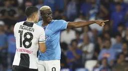 Pemain Napoli, Victor Osimhen, berbincang dengan pemain Udinese, Nehuen Perez, pada laga liga Italia di Stadion Diego Armando Maradona, Kamis (28/9/2023). Napoli menang dengan skor 4-1. (Alessandro Garofalo/LaPresse via AP)