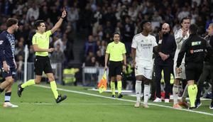 Wasit Alejandro Quintero memberikan kartu merah kepada bek Real Madrid asal Spanyol bernomor punggung 18, Alvaro Carreras (kanan), dalam pertandingan Liga Spanyol antara Real Madrid CF dan RC Celta de Vigo di Stadion Santiago Bernabeu, Madrid, Senin (8-12-2025) dini hari WIB. (Thomas COEX/AFP)
