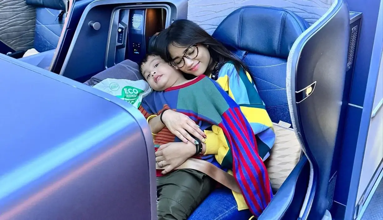 Momen liburan Gala dan Fuji ke luar negeri ini sembari merayakan ulang tahun mendiang ayah Gala, Bibi Adriansyah. Saat di bandara hingga di dalam pesawat, Fuji aktif bagikan kegiatan Gala yang antusias untuk liburan. Bak ibu untuk Gala, mantan Thariq Halilintar ini sangat sabar dan telaten mengurus Gala agar selalu merasa nyaman selama dalam perjalanan. (Liputan6.com/IG/@fuji_an)