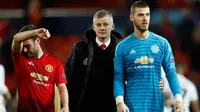 Pelatih sementara MU, Ole Gunnar Solskjaer bersama Juan Mata dan David de Gea berjalan meninggalkan lapangan usai pertandingan melawan PSG pada babak 16 besar Liga Champions di stadion Old Trafford (12/2). MU takluk atas PSG 2-0. (AP Photo/Martin Rickett)