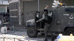 Seorang paramiliter petugas polisi perbatasan Israel melemparkan gas air mata ke warga Palestina saat bentrokan di Kota Nablus, Tepi Barat, 22 Februari 2023. Menurut Kementerian Kesehatan Palestina setidaknya 102 orang terluka, 82 terkena peluru tajam dan enam berada dalam kondisi kritis. (AP Photo/Majdi Mohammed)