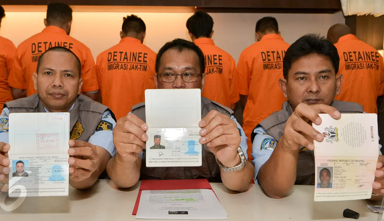 Petugas menunjukan pasport WNA saat rilis di kantor Imigrasi Kelas 1 Jakarta Timur, Rabu (18/1). Sebanyak 11 wna diamankan petugas imigrasi karena tidak memiliki surat resmi. (Liputan6.com/Yoppy Renato)