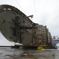 Petugas melintas didepan bangkai kapal Sewol yang berhasil diangkat di pulau barat daya Jindo, Korea Selatan (26/3). Kapal ini sebelumnya tenggelam hampir tiga tahun di kedalaman 44 meter. (HANDOUT / SOUTH KOREAN MARITIME MINISTRY / AFP)