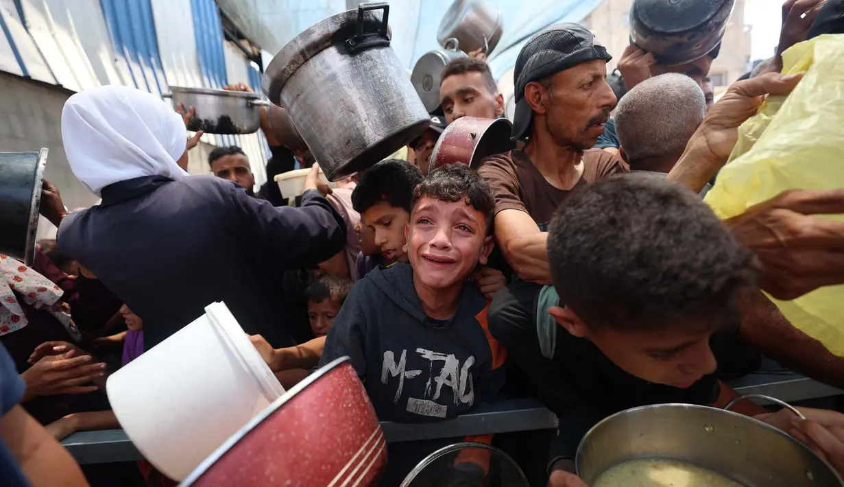 Salah satu anak Palestina menangis saat menunggu pembagian makanan di sebuah titik distribusi di Nuseirat, Jalur Gaza Tengah, pada 11 Juni 2025. (Eyad BABA/AFP)