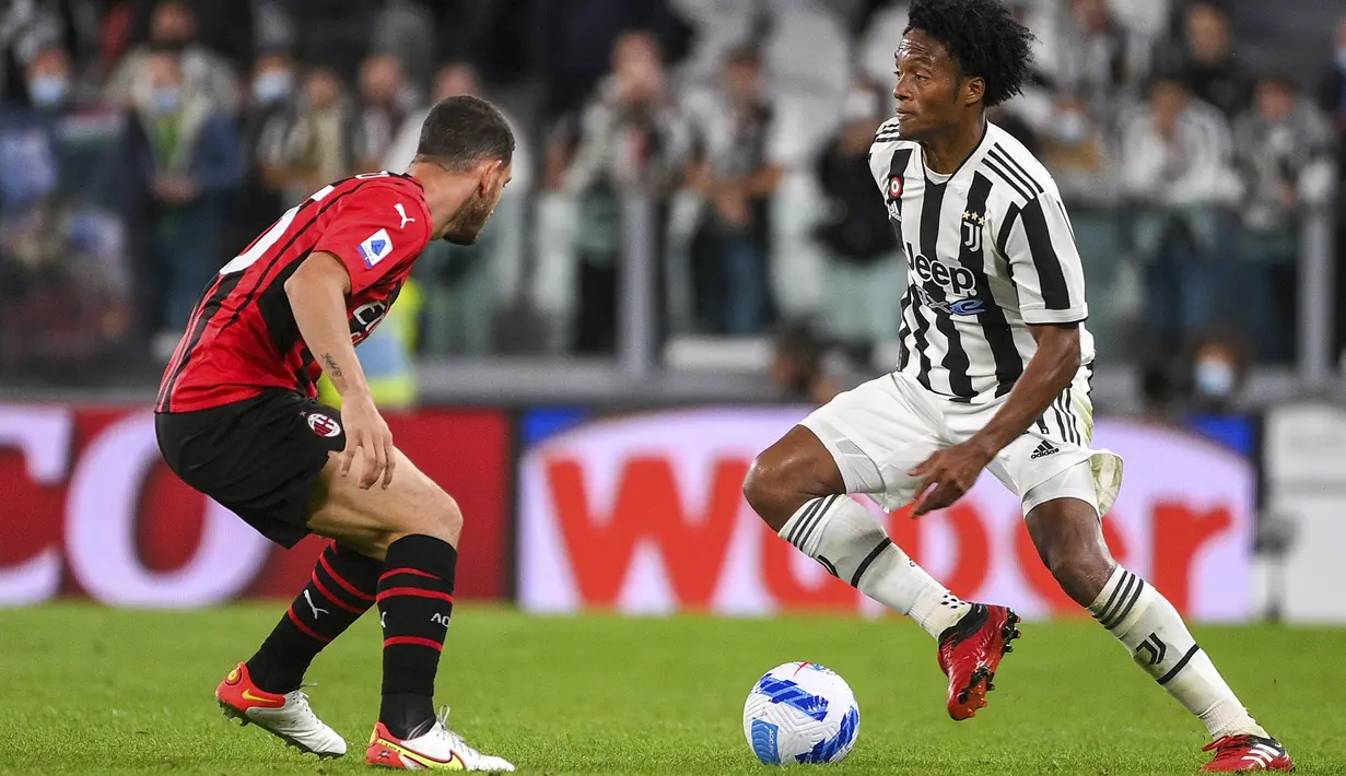 Gelandang Juventus, Juan Cuadrado (kanan) bersaing dengan bek AC Milan, Alessio Romagnoli pada pekan ke-4 Liga Italia di Allianz Stadium, Senin (20/9/2021) dini hari WIB. Menghadapi AC Milan, Juventus harus puas dengan hasil 1-1. (Marco Alpozzi/LaPresse via AP)