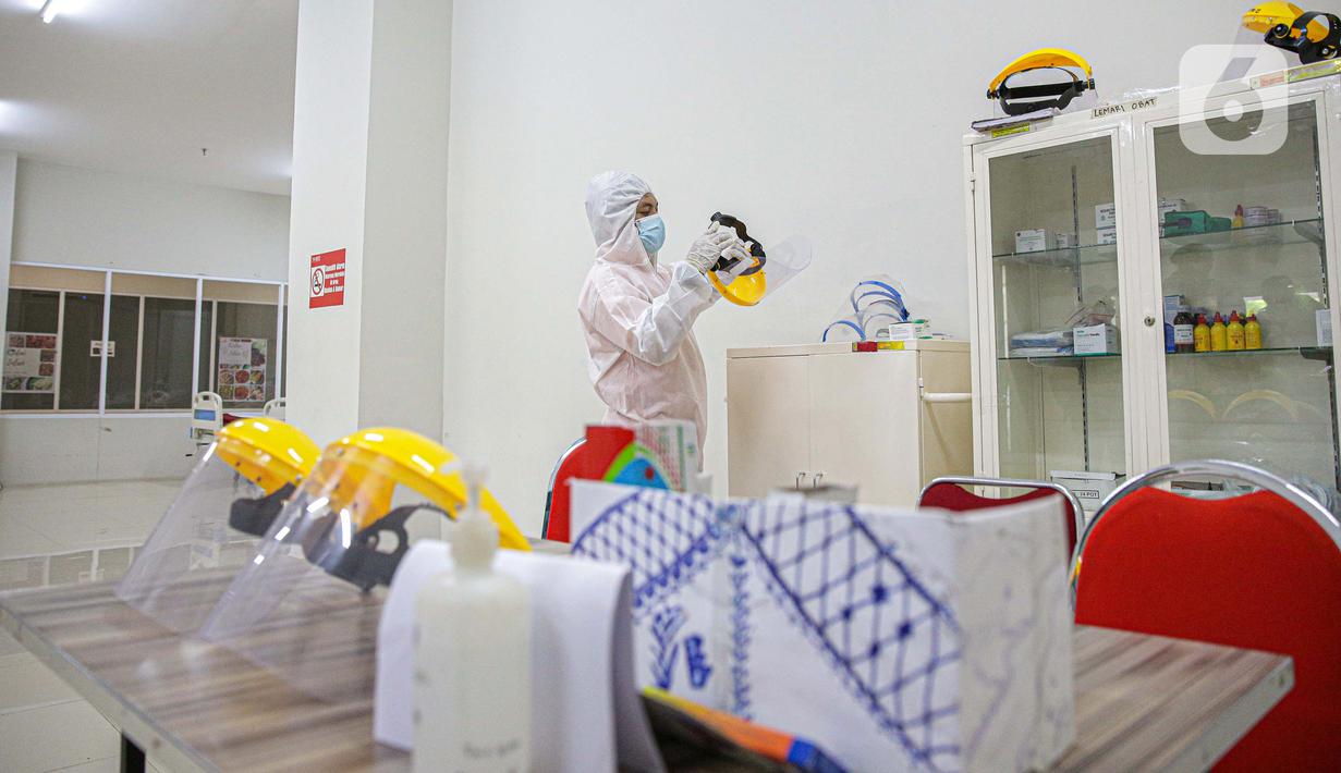 Petugas mengenakan hazmat saat menyiapkan peralatan di Tower 8 Wisma Atlet Pademangan, Jakarta, Selassa (15/6/2021). Tower 8 Wisma Atlet Pademangan bisa menampung 1.569 pasien untuk isolasi. (Liputan6.com/Faizal Fanani)