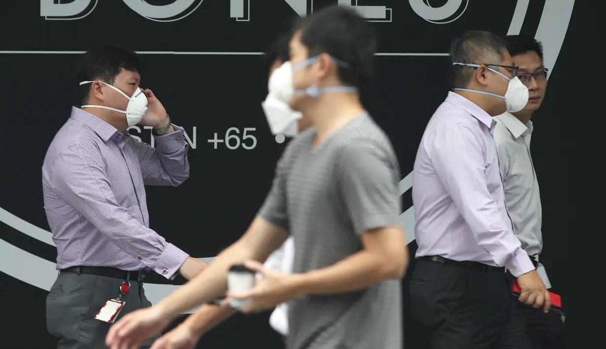 Warga Singapura menggunakan masker saat menjalankan aktivitas Singapura, Selasa (29/9/2015). Badan Lingkungan Hidup Nasional Singapura meningkatkan level kabut asap menjadi sangat tidak sehat (REUTERS/Edgar Su)