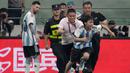 Seorang penyusup lapangan berlari menghindari kejaran petugas setelah memeluk pemain Argentina, Lionel Messi pada laga persahabatan antara Argentina melawan Australia di Workers' Stadium, Beijing, Kamis (15/06/2023). (AP Photo/Mark Schiefelbein)