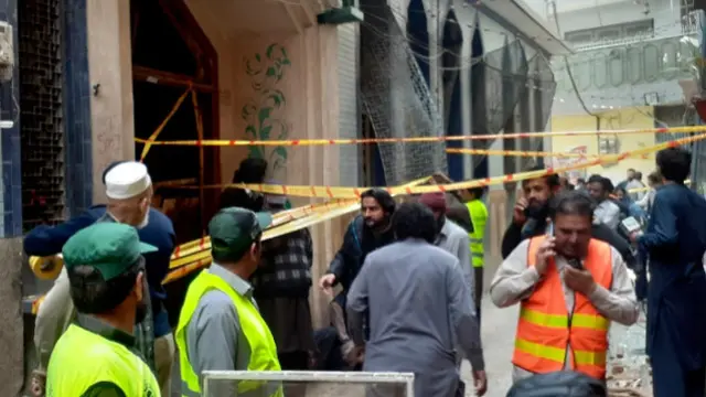Petugas penyelamat dan relawan berkumpul di lokasi ledakan bom di sebuah masjid Peshawar, Jumat4 Maret 2022.[Muhammad Sajjad/AP]