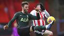 Pemain Tottenham Hotspur, Joe Rodon, berebut bola dengan pemain Sheffield United, Oliver Burke, pada laga Liga Inggris di Stadion Bramall Lane, Minggu (17/1/2021). Tottenham Hotspur menang dengan skor 3-1. (Laurence Griffiths/Pool via AP)