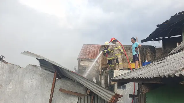 Petugas DPKP Kota Depok saat memadamkan api yang membakar gudang plastik di Pasar Kemirimuka, Depok.