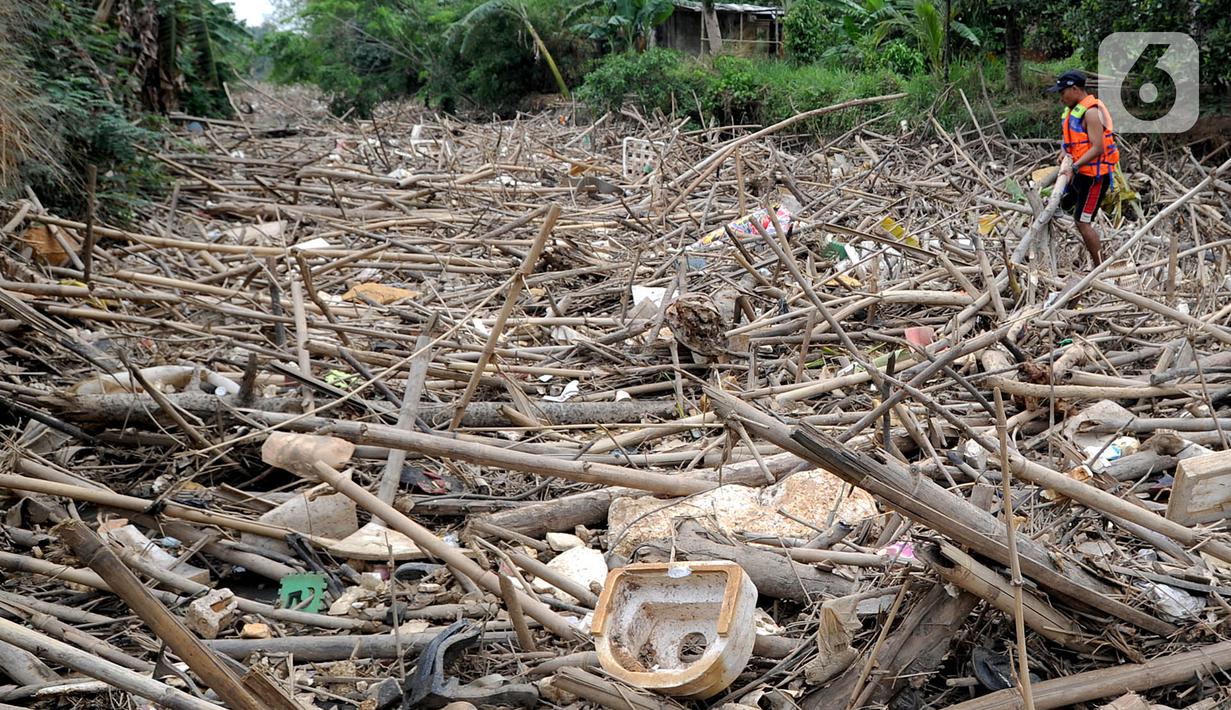 Petugas gabungan membersihkan tumpukan sampah yang menyumbat aliran air Sungai Cikeas di kawasan Bendung Koja Jatiasih, Bekasi, Jawa Barat, Rabu (16/10/2019). Pembersihan sekitar 1.200 meter kubik sampah bambu tersebut diperkirakan menghabiskan waktu dua minggu. (merdeka.com/Arie Basuki)