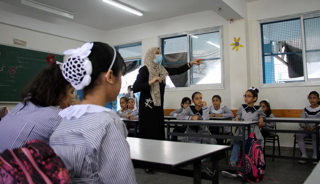 Para siswa duduk dalam kelas pada hari pertama tahun ajaran baru di kamp pengungsi Shati, Gaza City, Palestina, 8 Agustus 2020. Siswa Palestina dari Jalur Gaza memulai tahun ajaran baru setelah sekolah ditutup selama lima bulan karena COVID-19. (Xinhua/Rizek Abdeljawad)